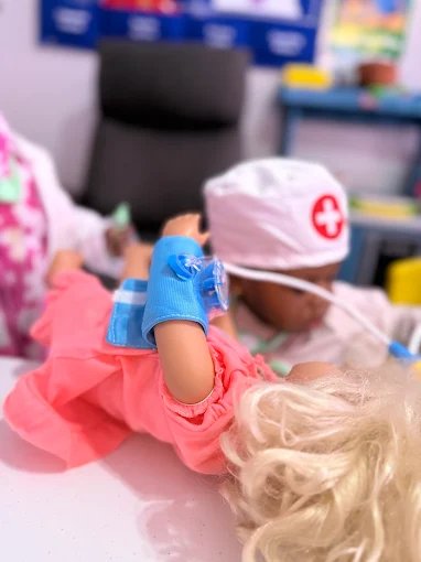Child playing with kitchen toys in imaginative play at Graceland Kids Center