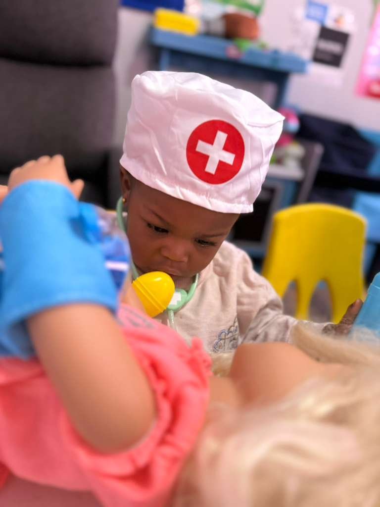 Child exploring toy food during sensory play at Graceland Kids Center