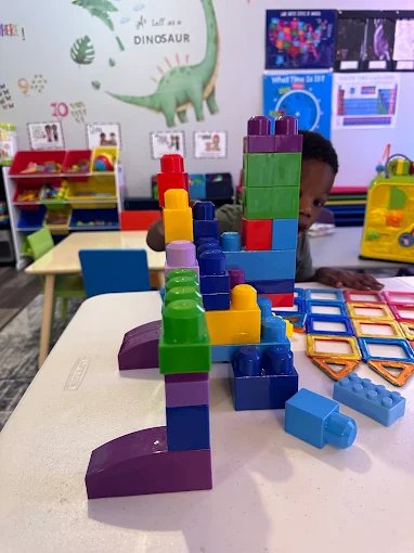 Child building with blocks during creative play at Graceland Kids Center